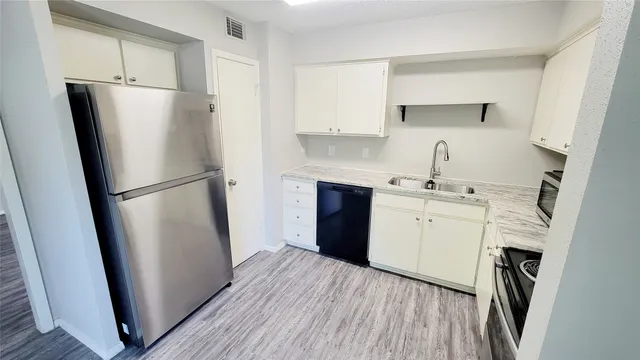 a kitchen with a refrigerator sink stove and cabinets