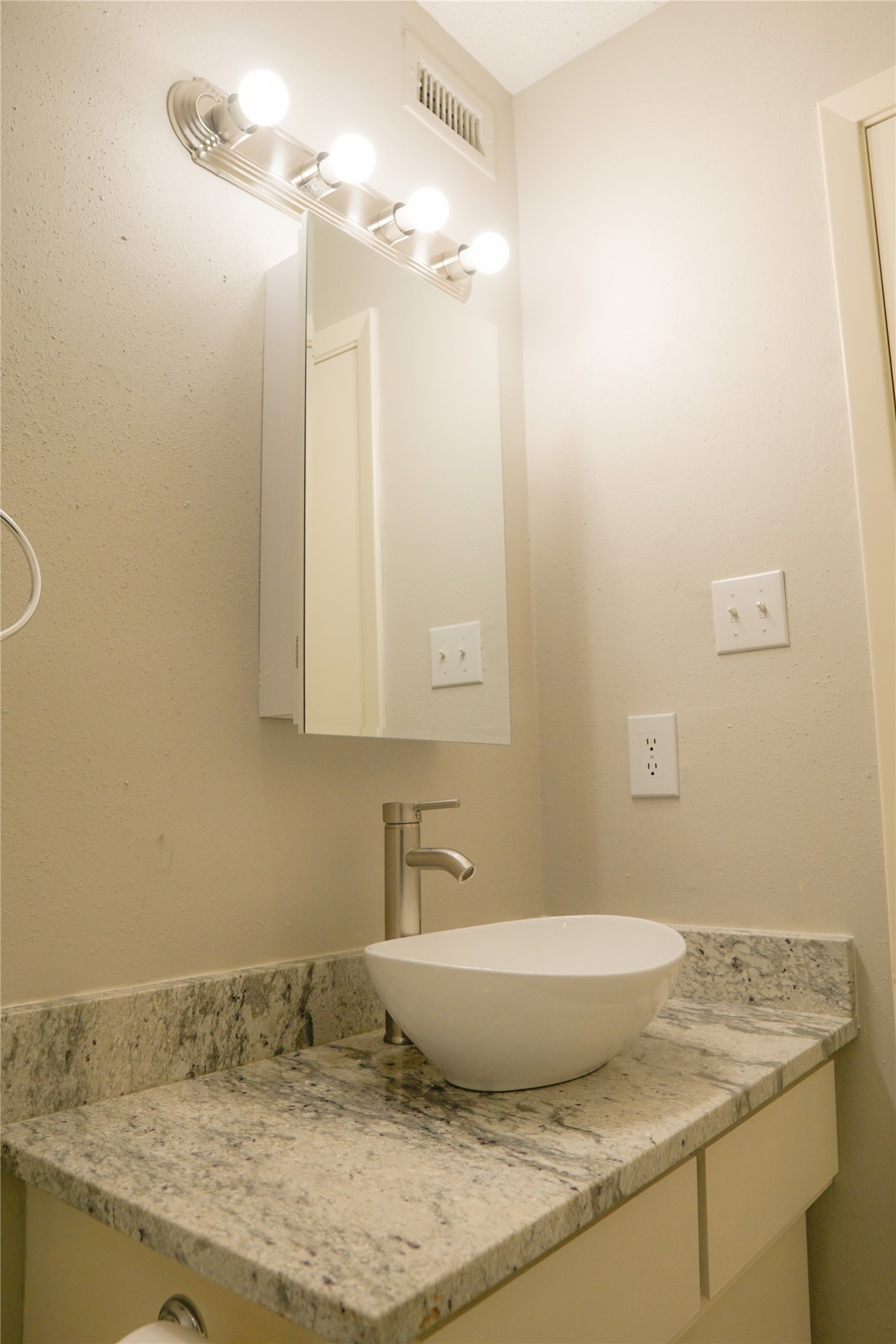 12004 Mighty Oak Drive, Unit B Houston, TX 77066 - Photo 6 of 9 a bathroom with a granite countertop sink and a mirror