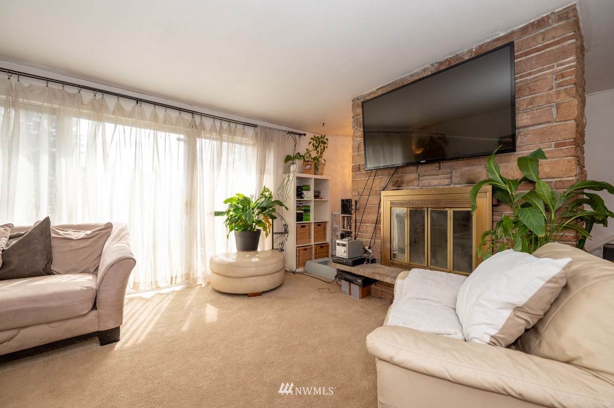 14235 169th Avenue Southeast Renton, WA 98059 - Photo 7 of 25 a living room with furniture potted plant and a window