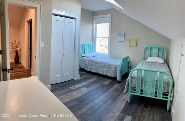 a bedroom with two beds and painting on the wall