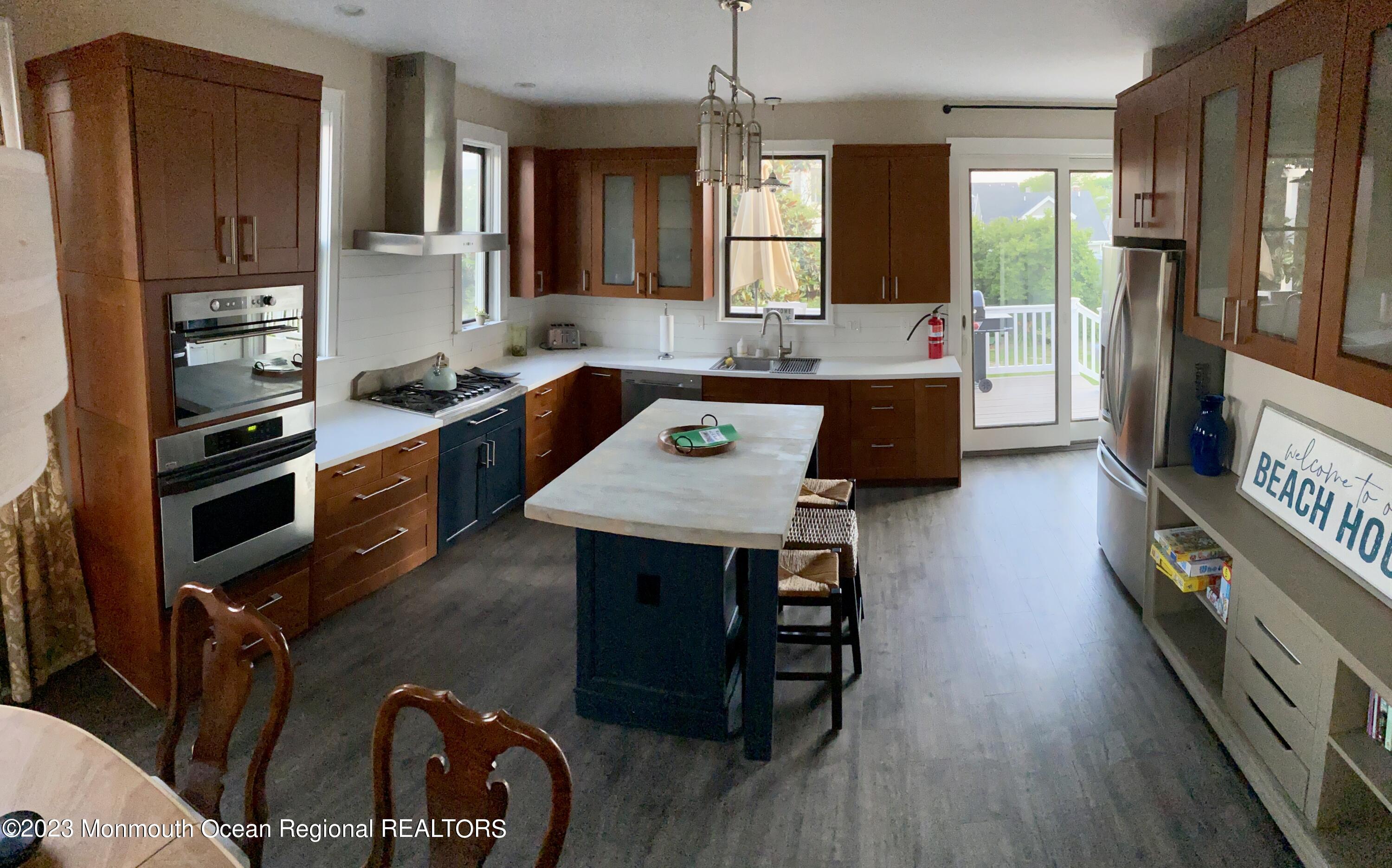 447 East Main Street Manasquan, NJ 08736 - Photo 4 of 18 a kitchen with a refrigerator a stove a sink dishwasher and wooden cabinets with wooden floor