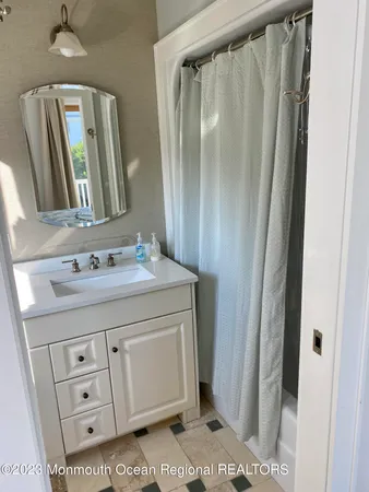 a bathroom with a granite countertop sink a mirror a vanity and a shower