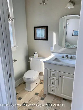 a bathroom with a granite countertop toilet a sink and a mirror