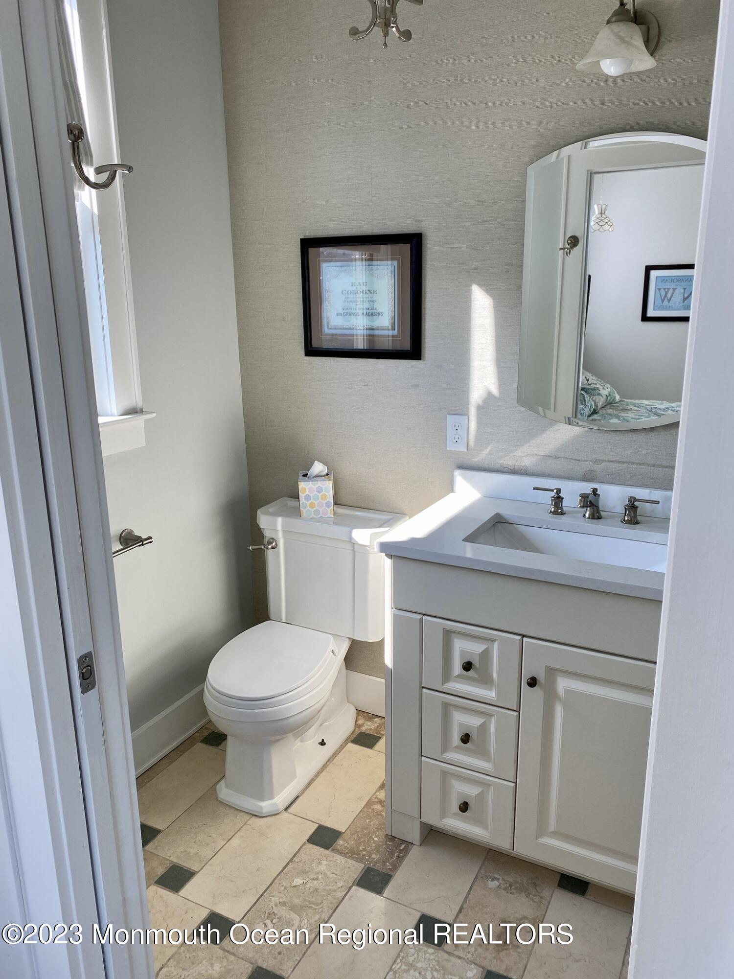 447 East Main Street Manasquan, NJ 08736 - Photo 7 of 18 a bathroom with a granite countertop toilet a sink and a mirror