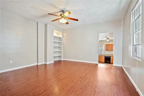 an empty room with wooden floor chandelier and entryway