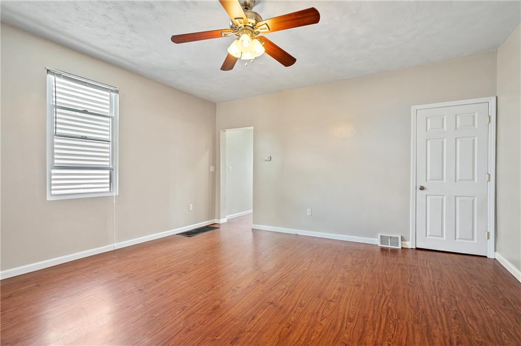 4524 Minerva Street Pittsburgh, PA 15224 - Photo 6 of 28 an empty room with wooden floor chandelier fan and windows