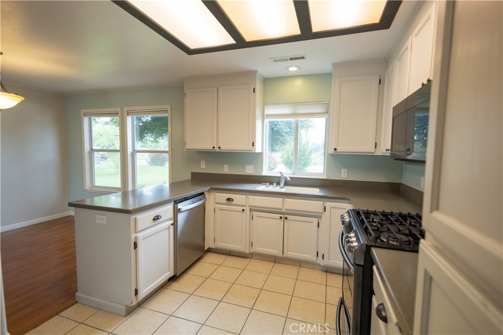 6042 Grange Road Corning, CA 96021 - Photo 12 of 38 a kitchen with stainless steel appliances granite countertop a sink and a stove
