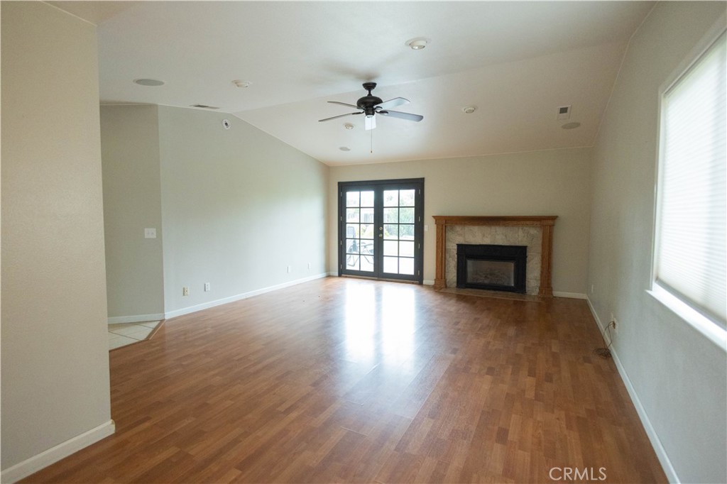 6042 Grange Road Corning, CA 96021 - Photo 9 of 38 an empty room with wooden floor fireplace and windows