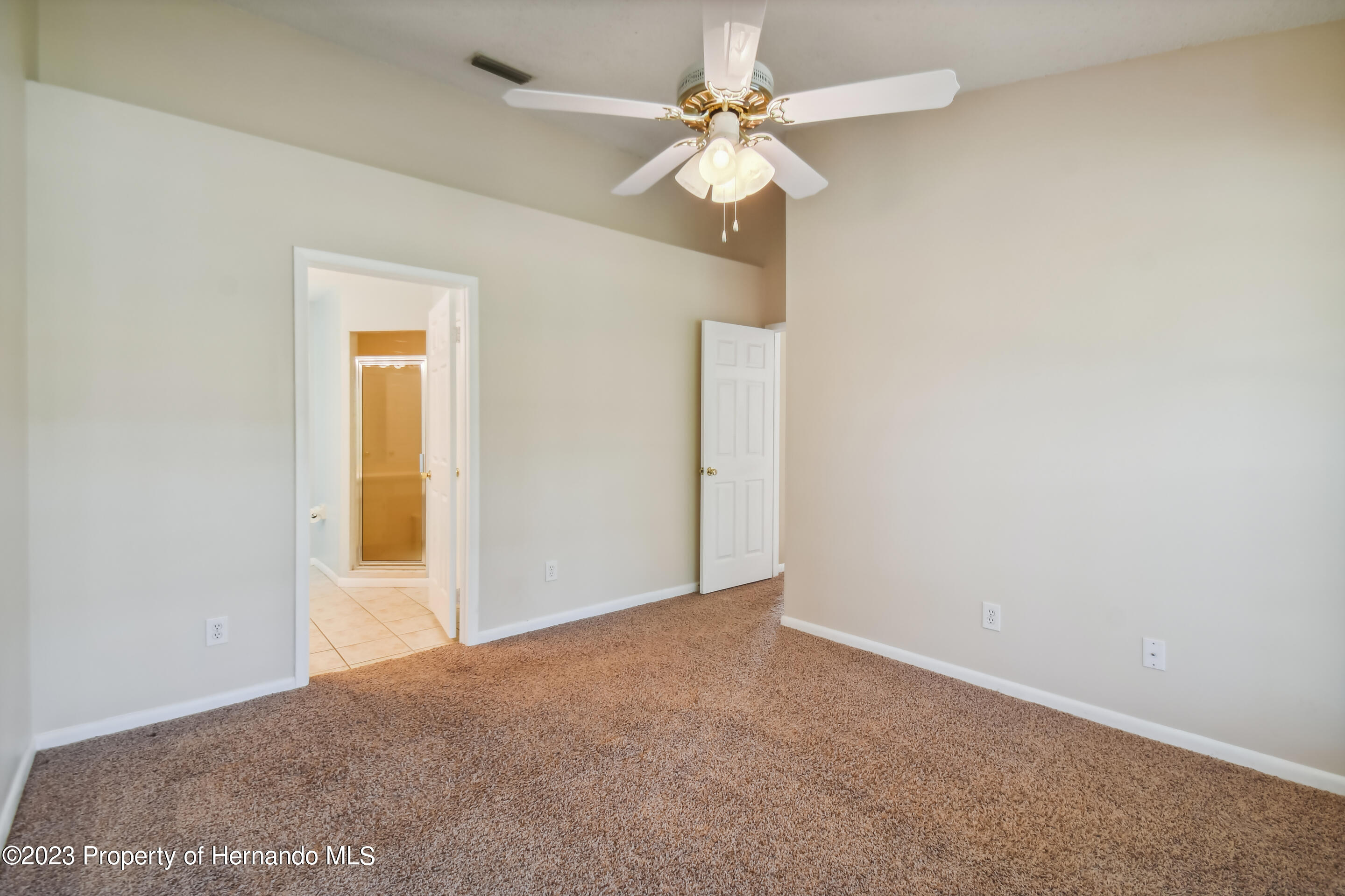1735 Elk Spring Drive Brandon, FL 33511 - Photo 23 of 49 an empty room with a chandelier fan and windows