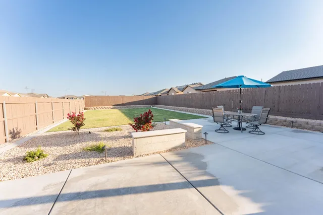 a view of a patio with a table and chairs under an umbrella