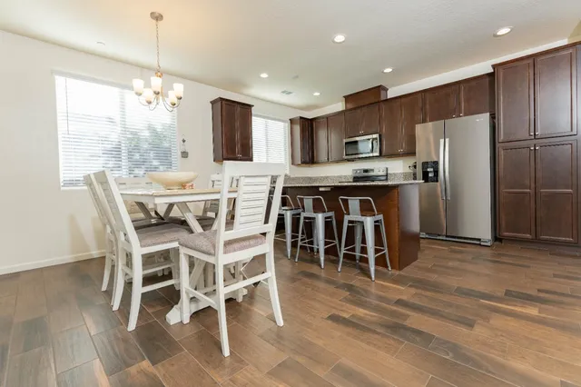 a kitchen with kitchen island granite countertop stainless steel appliances a sink and a refrigerator