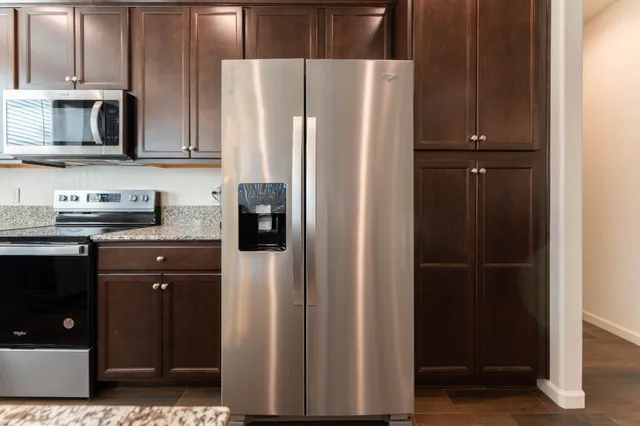 a kitchen with stainless steel appliances granite countertop a refrigerator and a sink