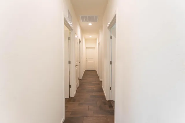 a view of a hallway with wooden floor
