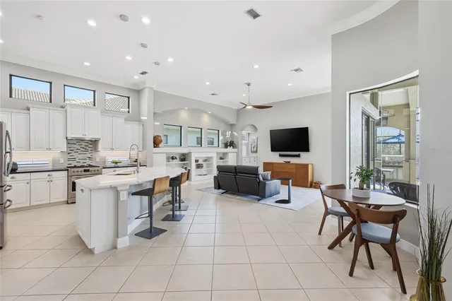 a kitchen with a dining table chairs sink and cabinets