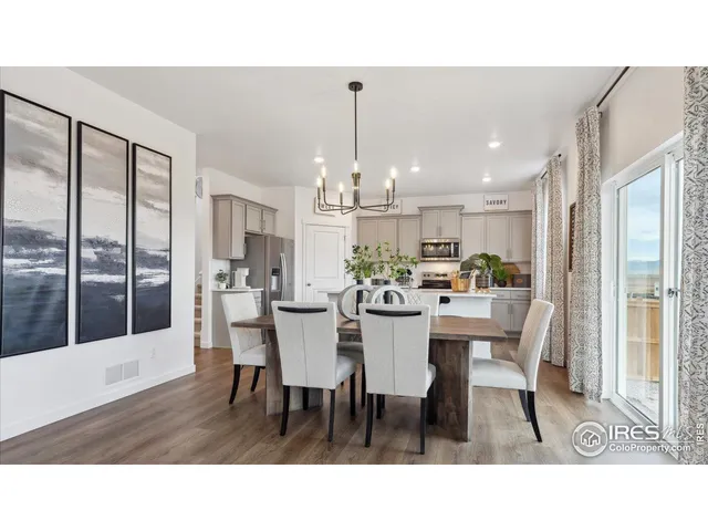 a dining room with furniture a chandelier and window