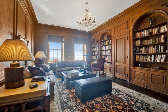 a living room with furniture a chandelier and a rug