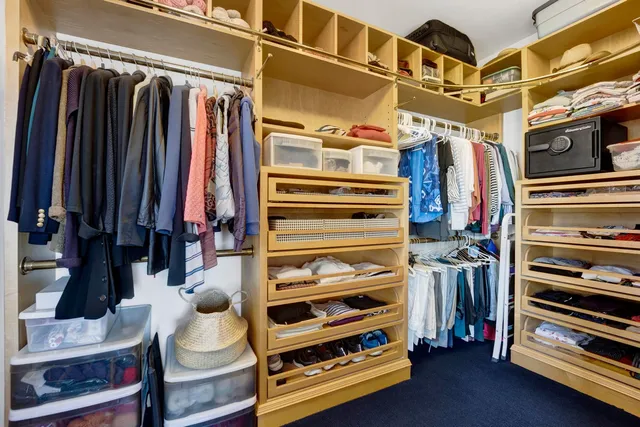 a view of walk in closet with clothes and shoes