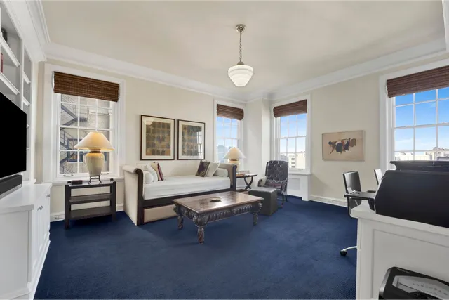 a living room with furniture wooden floor and a large window
