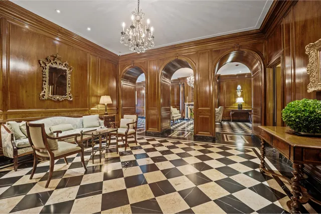 a living room with a black white checkered floor with couches chair and a coffee table