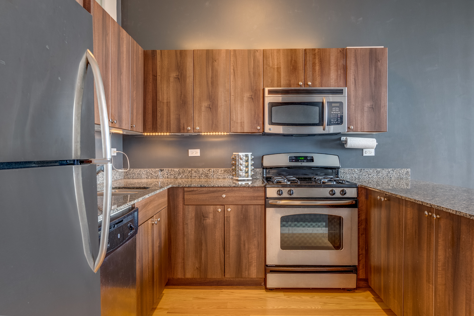 235 West Van Buren Street, Unit 3011 Chicago, IL 60607 - Photo 11 of 30 a kitchen with granite countertop a stove top oven and cabinets