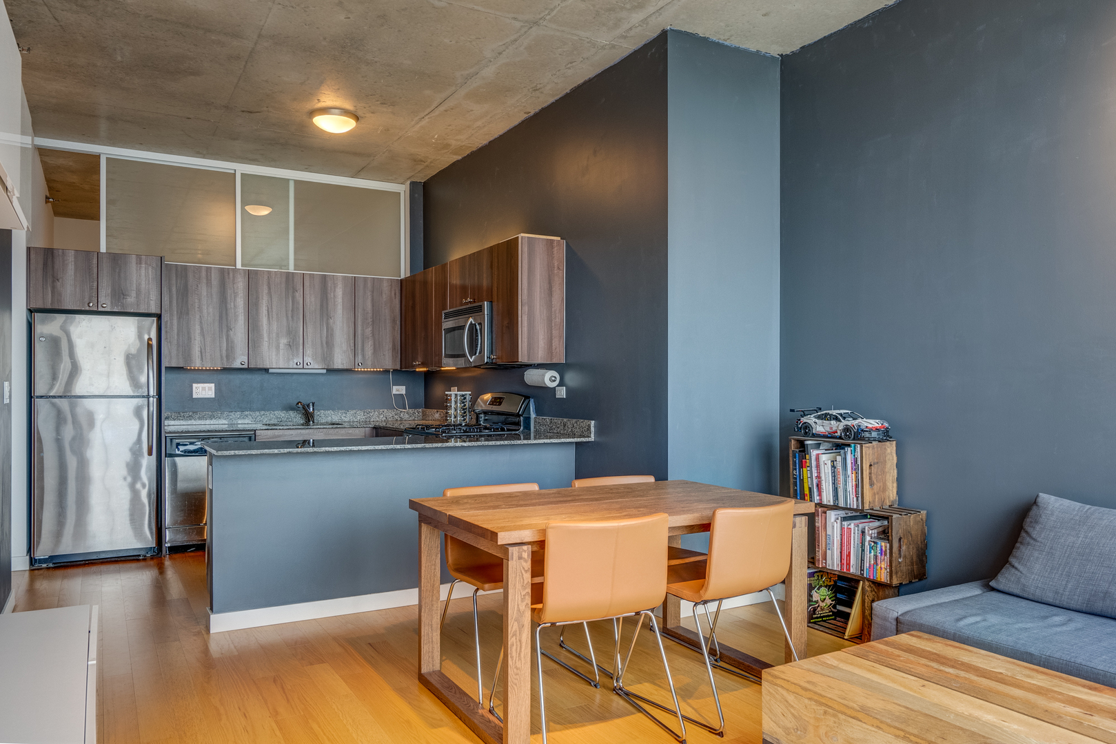 235 West Van Buren Street, Unit 3011 Chicago, IL 60607 - Photo 13 of 30 a kitchen with a table chairs refrigerator and a cabinets
