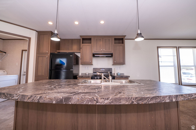2491 Highway 89, Unit 403 Pleasant View, UT 84404 - Photo 6 of 32 Kitchen island featuring a double basin sink and stone-look countertop