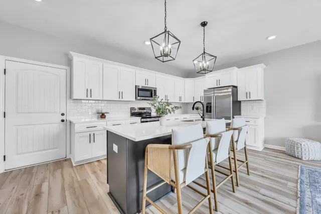 a kitchen with stainless steel appliances a stove center island refrigerator and cabinets