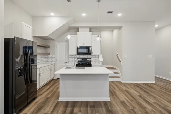 a kitchen with kitchen island a sink stainless steel appliances and cabinets
