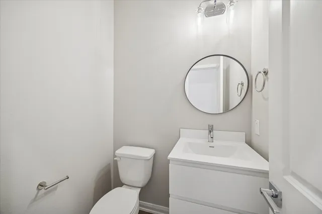 a bathroom with a sink mirror and toilet