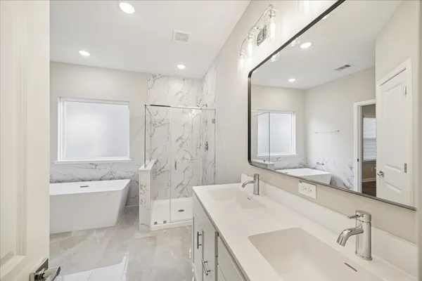 a bathroom with a double vanity sink mirror double and bathtub