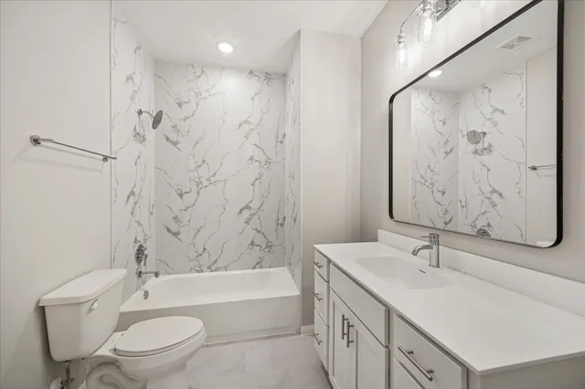 a bathroom with a bathtub sink mirror toilet and a shower