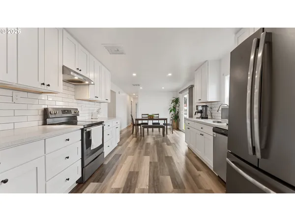 a open kitchen with cabinets stainless steel appliances a sink and living room view