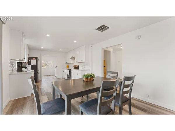 a living room with stainless steel appliances kitchen island granite countertop furniture and a dining table