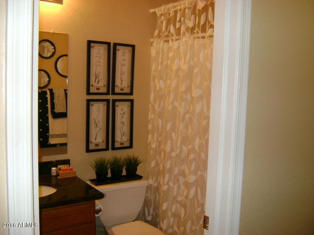 11174 West Berkeley Road Avondale, AZ 85392 - Photo 8 of 41 a bathroom with a toilet and a shower curtain