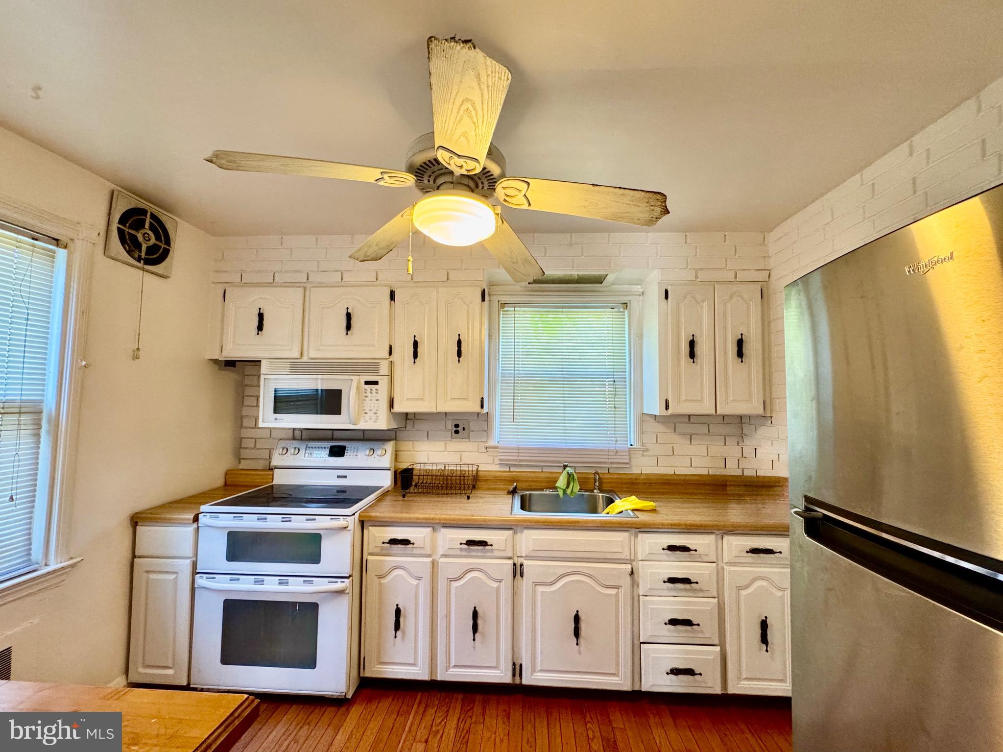 3913 Loch Raven Boulevard Baltimore, MD 21218 - Photo 12 of 38 a kitchen with stainless steel appliances a stove a sink cabinets and wooden floor