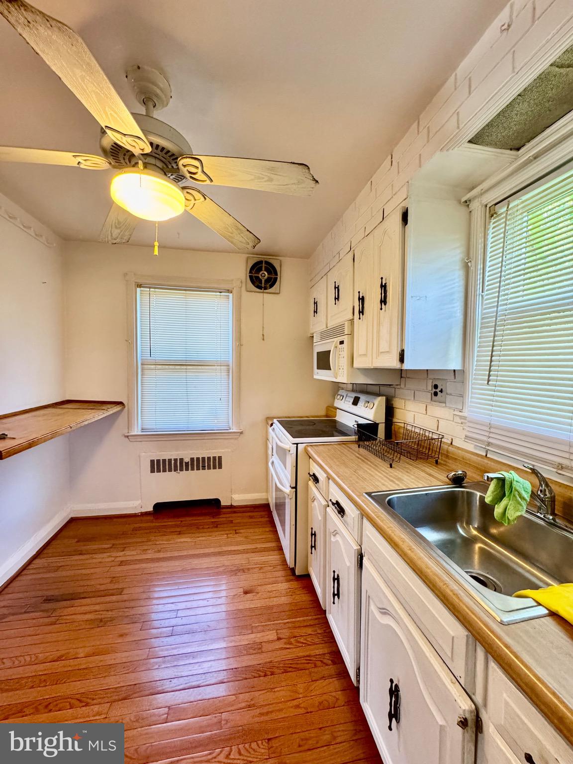 3913 Loch Raven Boulevard Baltimore, MD 21218 - Photo 13 of 38 a large kitchen with stainless steel appliances a large counter top a stove a chimney a sink and a window