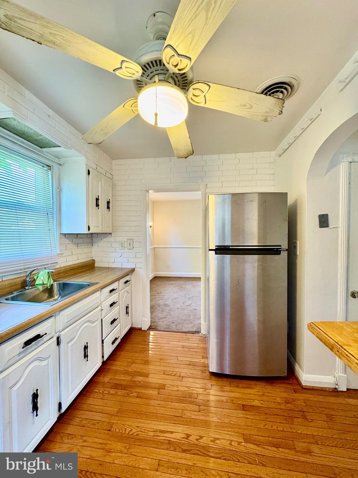 3913 Loch Raven Boulevard Baltimore, MD 21218 - Photo 14 of 38 a kitchen with stainless steel appliances granite countertop a refrigerator a sink dishwasher a stove and white cabinets with wooden floor