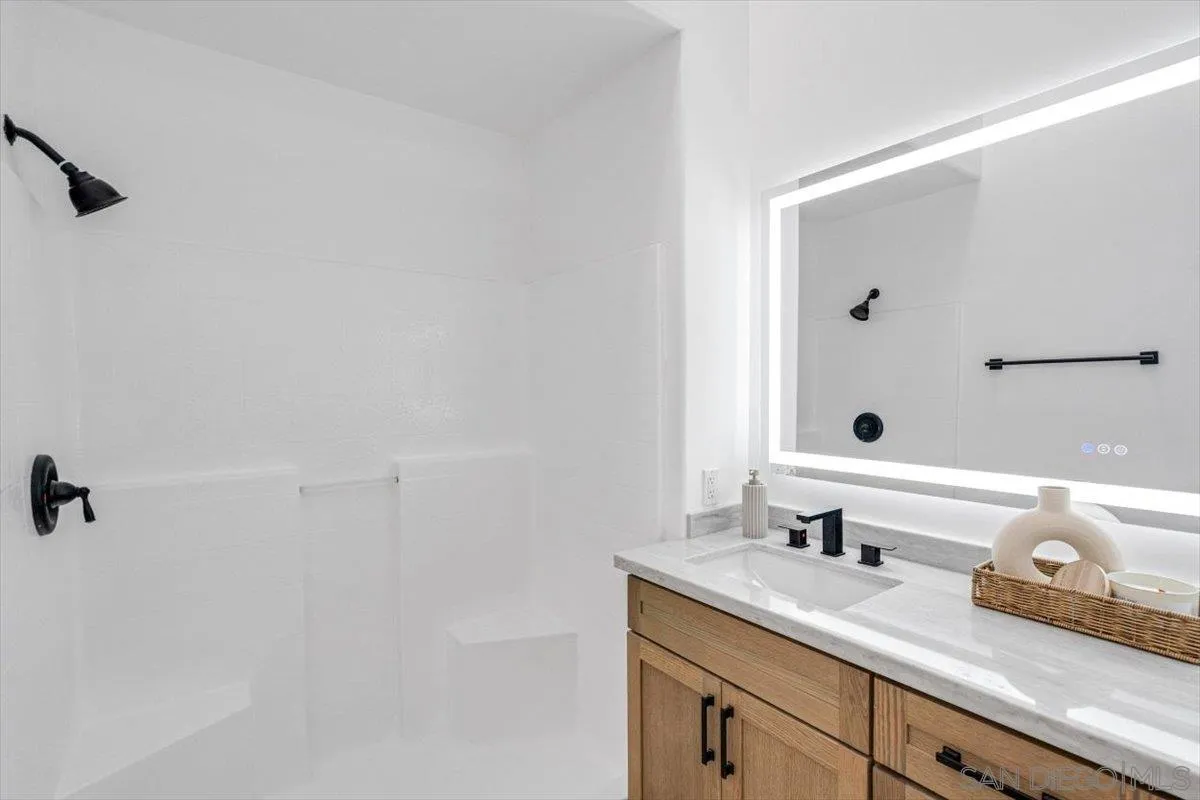 12865 Carriage Heights Way Poway, CA 92064 - Photo 24 of 42 a bathroom with a granite countertop sink a mirror and shower