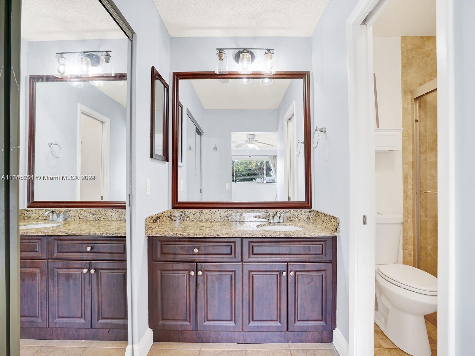 9727 Hammocks Boulevard, Unit 201D Miami, FL 33196 - Photo 15 of 25 a bathroom with a granite countertop sink and a mirror