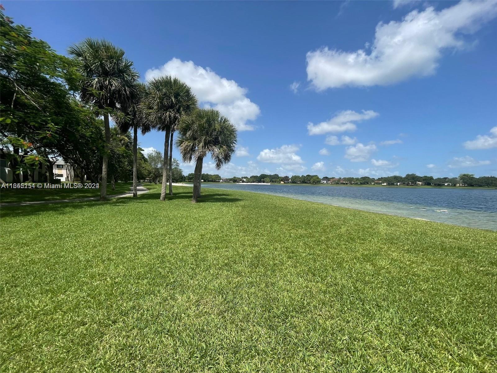 9727 Hammocks Boulevard, Unit 201D Miami, FL 33196 - Photo 21 of 25 a view of a lake with a big yard