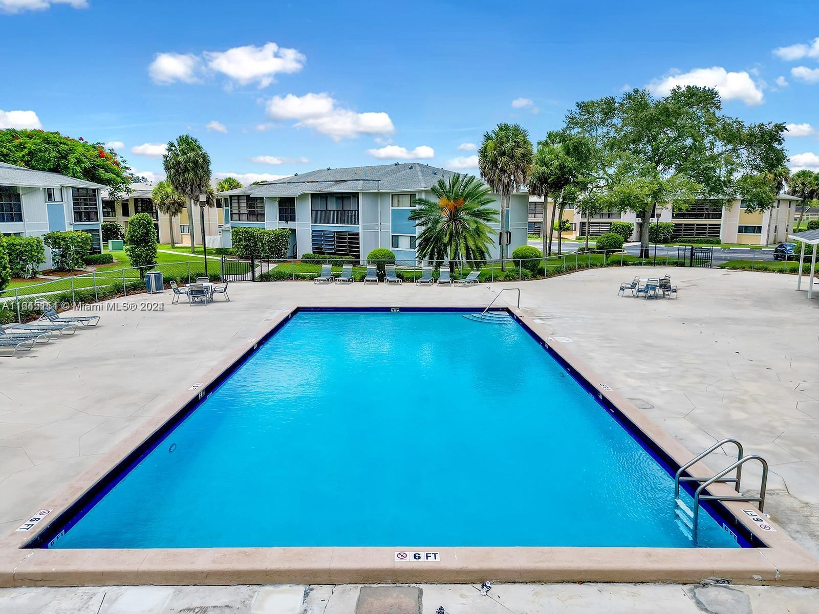 9727 Hammocks Boulevard, Unit 201D Miami, FL 33196 - Photo 23 of 25 a view of swimming pool with outdoor seating and house in the background