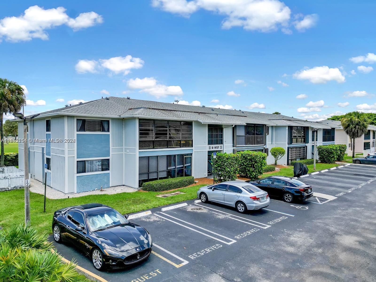 9727 Hammocks Boulevard, Unit 201D Miami, FL 33196 - Photo 25 of 25 a car parked in front of a brick house with a yard