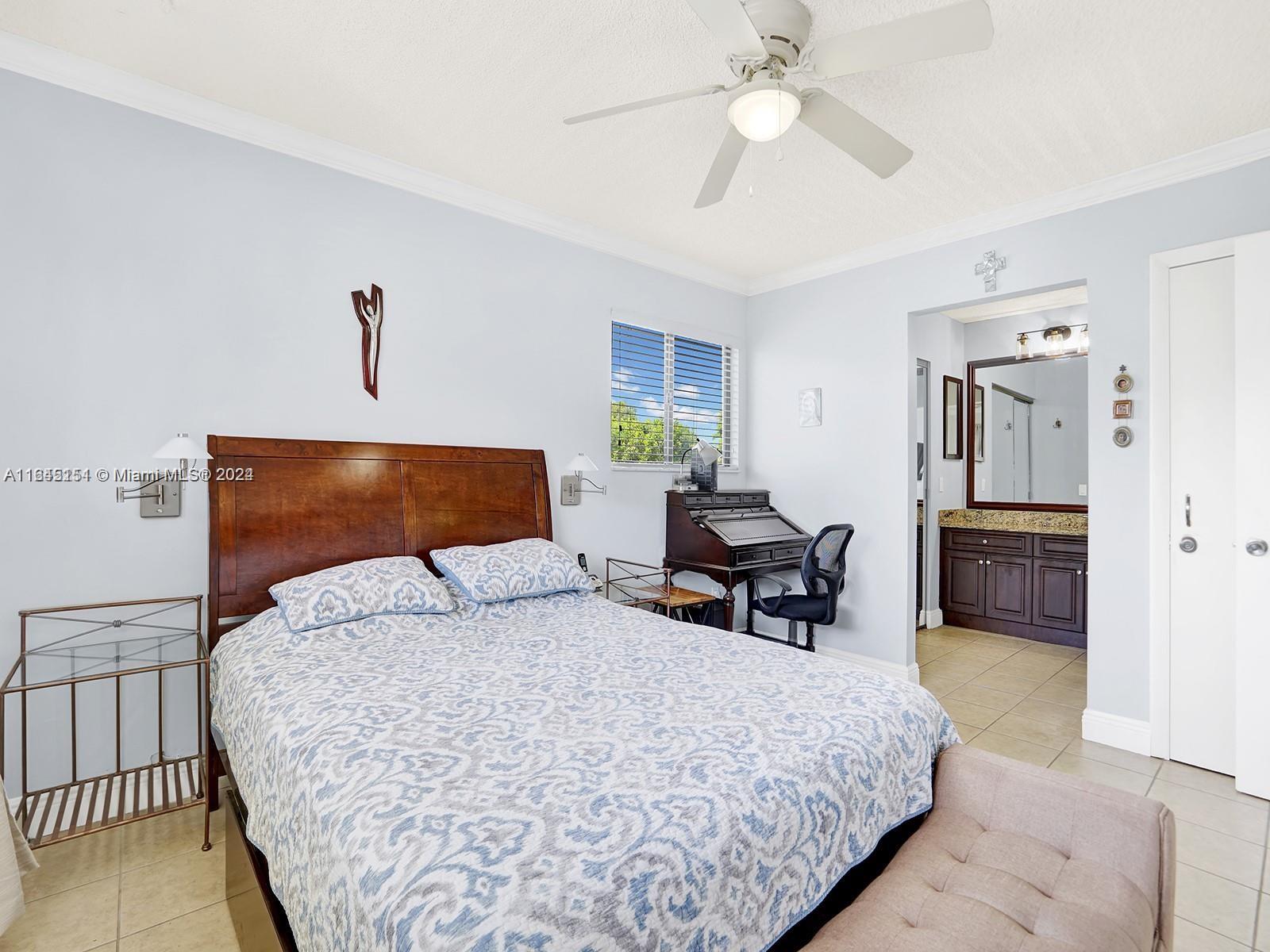 9727 Hammocks Boulevard, Unit 201D Miami, FL 33196 - Photo 3 of 25 a bedroom with bed and a chandelier