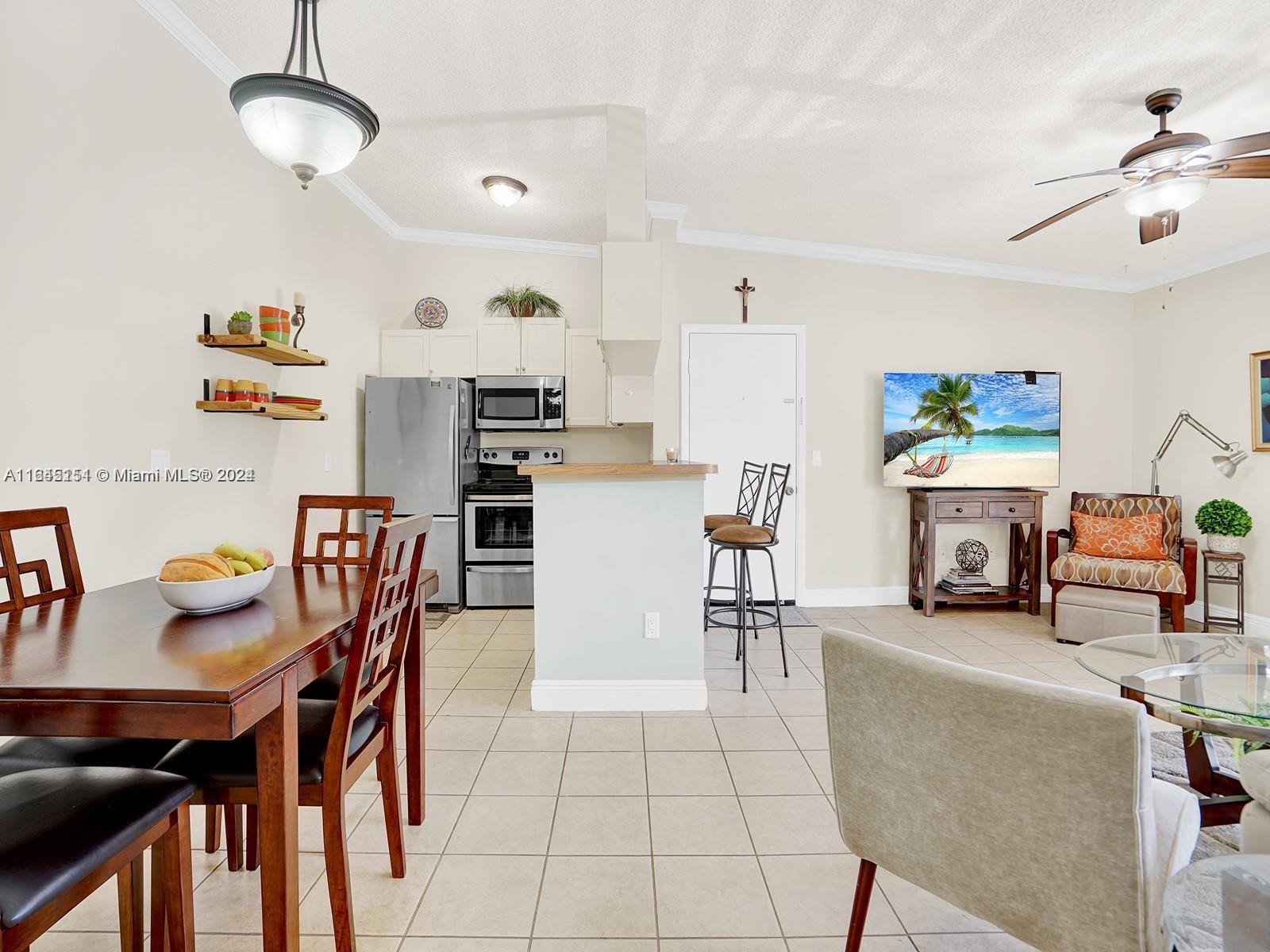 9727 Hammocks Boulevard, Unit 201D Miami, FL 33196 - Photo 10 of 25 a living room with furniture and a chandelier