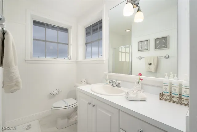 a bathroom with a sink a toilet and mirror