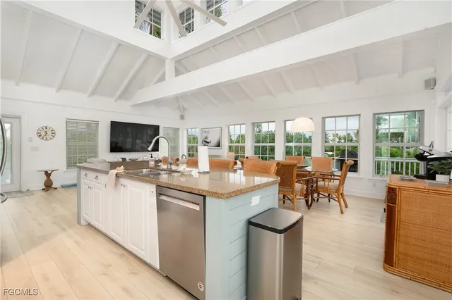 a kitchen with stainless steel appliances granite countertop a stove and a view of living room