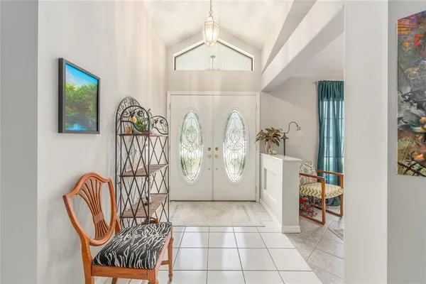 a living room with furniture a chandelier fan and a window