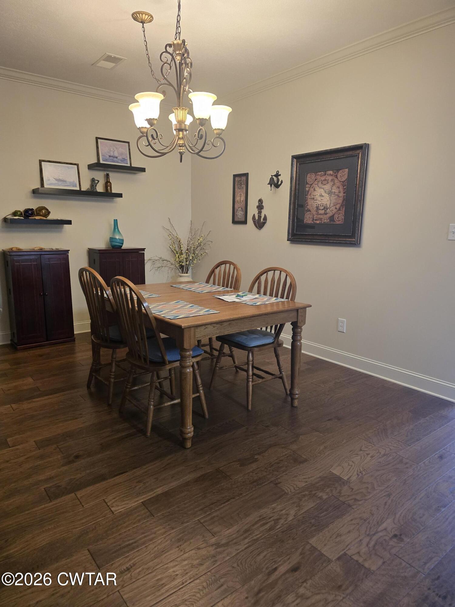 61 Emerald Ridge Cove Jackson, TN 38305 - Photo 6 of 24 a dining room with wooden floor a chandelier a wooden table and chairs