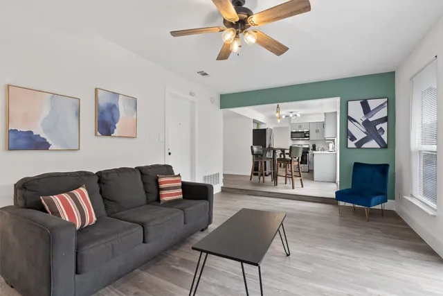 a living room with furniture and a wooden floor