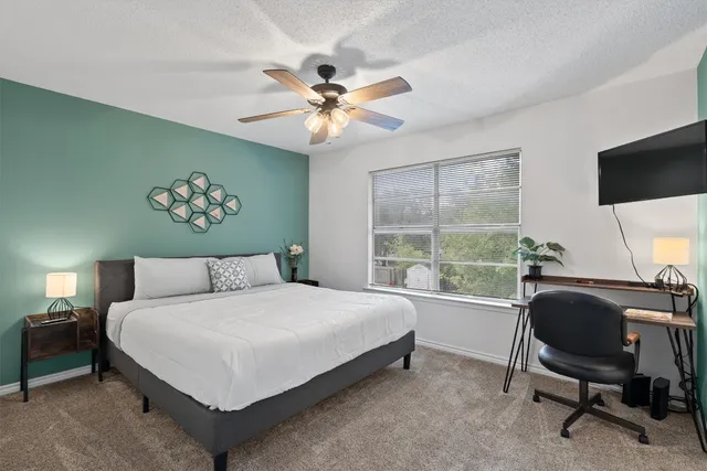 a bedroom with a large bed and a chandelier